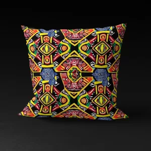 Front view of Ashanti Dreamweaver pillow cover against a black background, featuring kaleidoscopic patterns in yellow, green, black, and red with an enigmatic animal-like figure at the center.